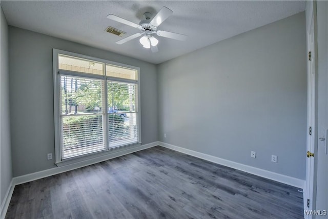 empty room featuring a textured ceiling, ceiling fan, and dark hardwood / wood-style floors