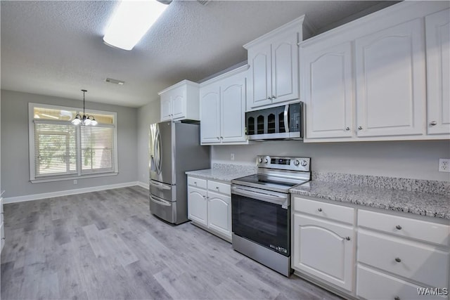 kitchen featuring a chandelier, appliances with stainless steel finishes, white cabinetry, and hanging light fixtures