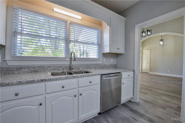 kitchen featuring light stone countertops, stainless steel dishwasher, sink, light hardwood / wood-style flooring, and white cabinets