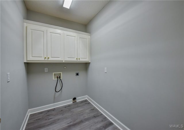 laundry room featuring cabinets, electric dryer hookup, hookup for a gas dryer, hookup for a washing machine, and light hardwood / wood-style floors