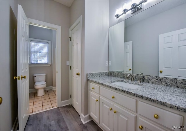 bathroom with vanity, wood-type flooring, and toilet