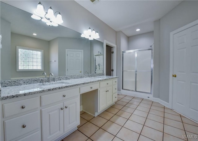 bathroom featuring tile patterned flooring, vanity, a chandelier, and walk in shower