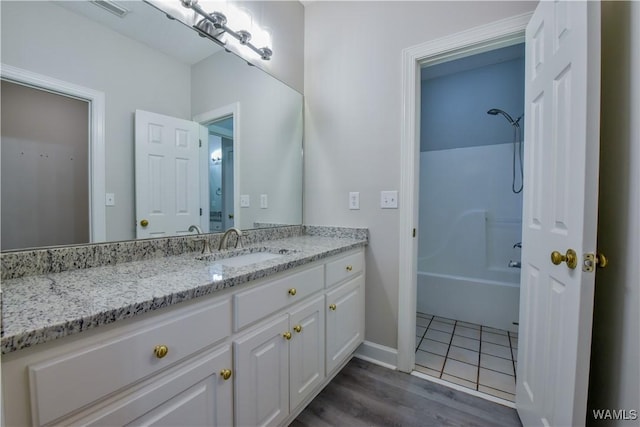 bathroom with vanity, wood-type flooring, and shower / washtub combination