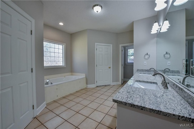 bathroom featuring vanity, tile patterned floors, a textured ceiling, a notable chandelier, and a tub