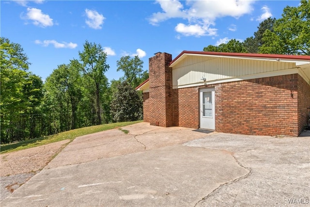 7665 Baptist Campground Rd, Northport, AL 35473 - view of side of home featuring brick siding, a patio, and a chimney