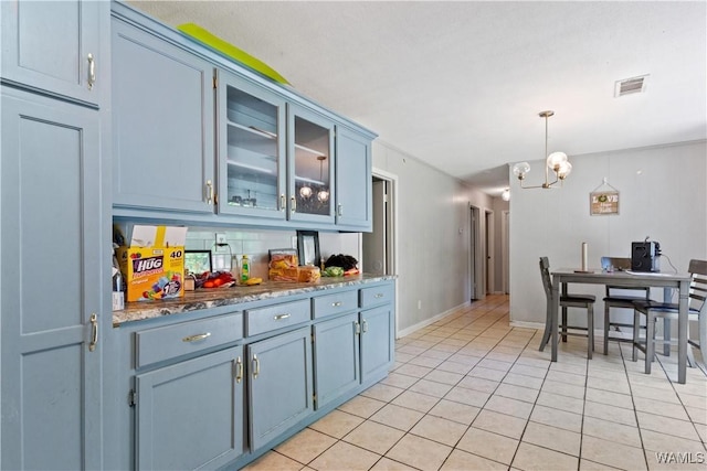 7665 Baptist Campground Rd, Northport, AL 35473 - kitchen with hanging light fixtures, light tile patterned flooring, a chandelier, glass insert cabinets, and visible vents