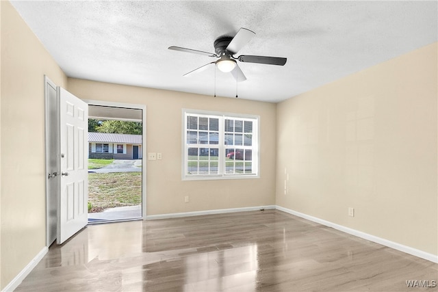 spare room featuring a textured ceiling, light hardwood / wood-style floors, and ceiling fan