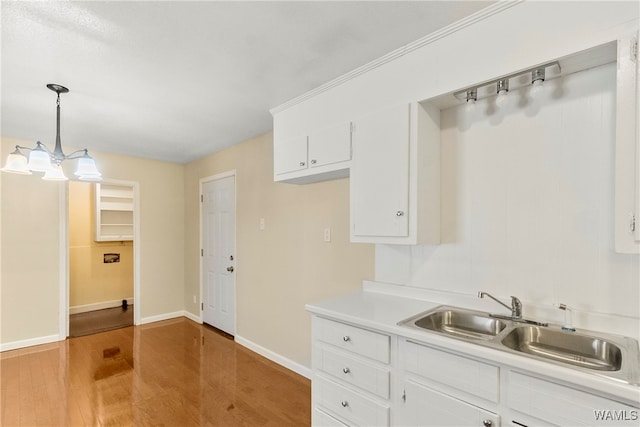 kitchen with white cabinets, wood-type flooring, and decorative light fixtures