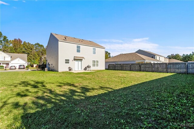 rear view of house featuring a lawn and a patio area