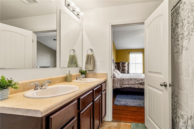 bathroom with hardwood / wood-style floors, vanity, and vaulted ceiling