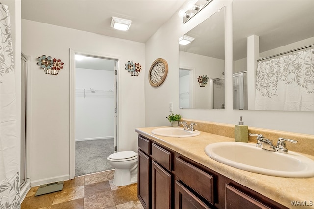 bathroom featuring toilet, vanity, and walk in shower