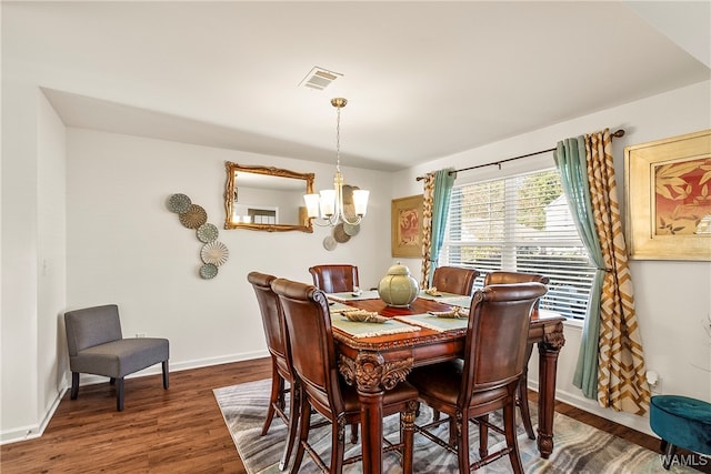 dining room with a notable chandelier and dark wood-type flooring