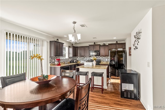 dining room featuring wine cooler, sink, hardwood / wood-style floors, and an inviting chandelier