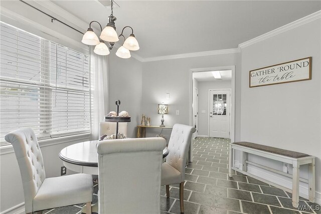 dining room featuring ornamental molding, a notable chandelier, plenty of natural light, and baseboards