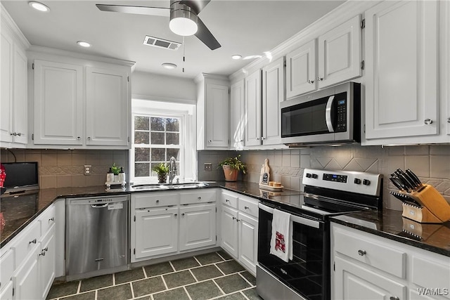 kitchen with tasteful backsplash, visible vents, stainless steel appliances, white cabinetry, and a sink