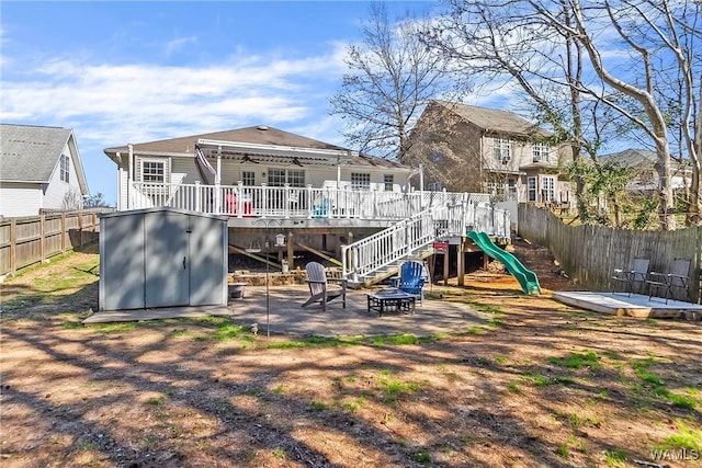 back of property featuring a ceiling fan, a patio, a fenced backyard, an outbuilding, and a shed