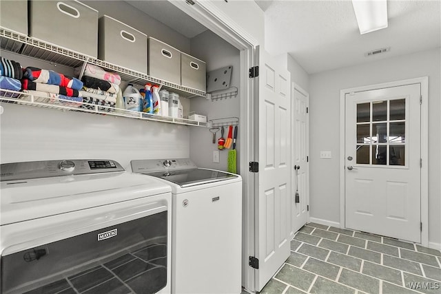 washroom with laundry area, washing machine and dryer, visible vents, and baseboards