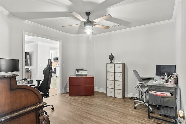 office space featuring baseboards, visible vents, ceiling fan, ornamental molding, and wood finished floors