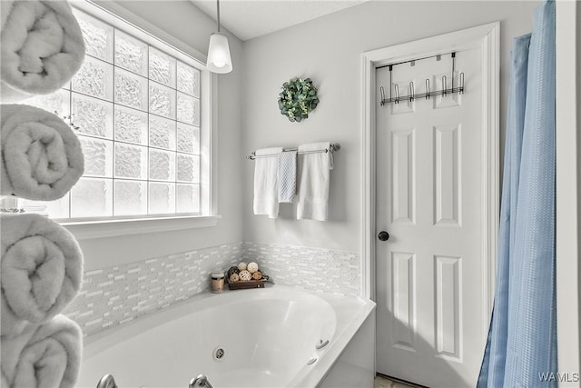 bathroom with a wealth of natural light and a jetted tub