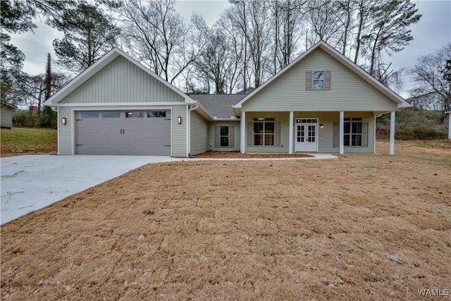 view of front of house with a garage, driveway, a porch, and a front yard