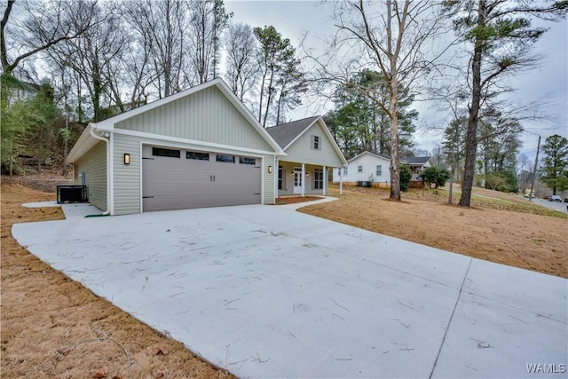 view of front of property featuring a garage, covered porch, and central air condition unit