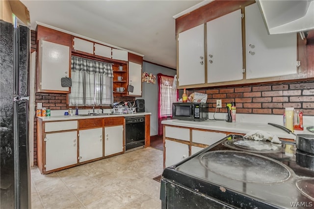 kitchen featuring black appliances, white cabinetry, and sink