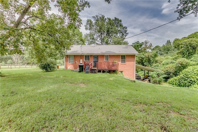 back of property featuring a carport and a lawn