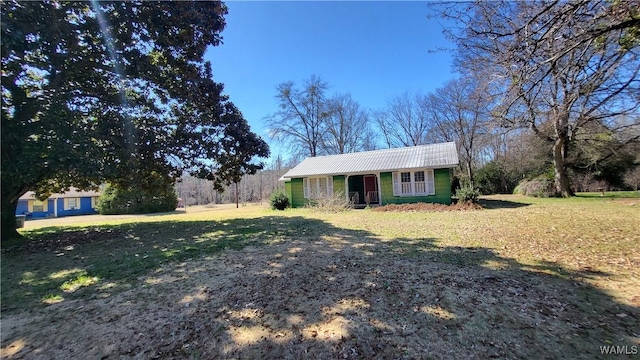 ranch-style house featuring metal roof and a front lawn