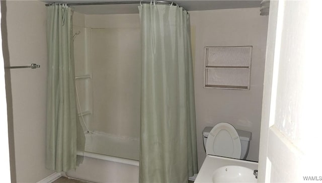 bathroom with toilet, curtained shower, and a sink