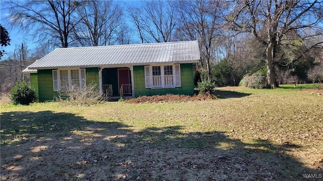 view of front of house featuring a front lawn and metal roof