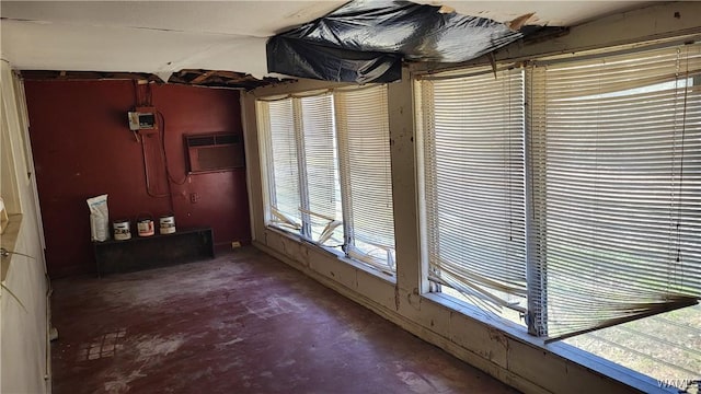 interior space featuring unfinished concrete flooring and a wall mounted AC