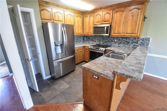 kitchen with sink, stainless steel appliances, tasteful backsplash, kitchen peninsula, and a breakfast bar area