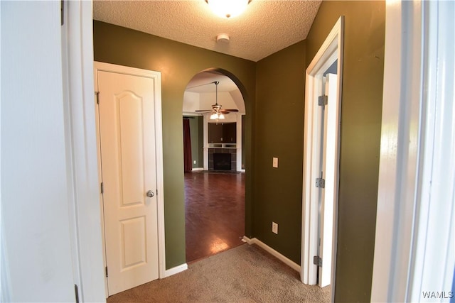 corridor with carpet flooring and a textured ceiling