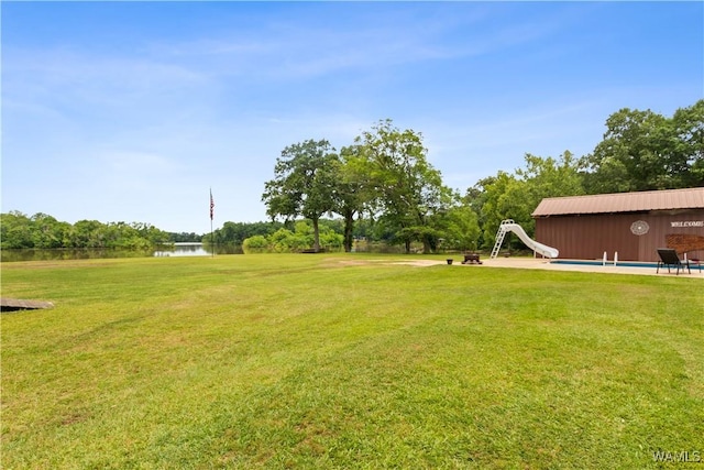 view of green lawn with a water view