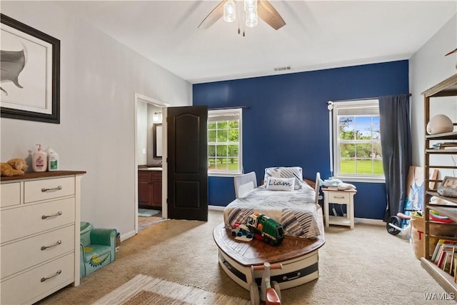 bedroom featuring light carpet, baseboards, ceiling fan, and connected bathroom