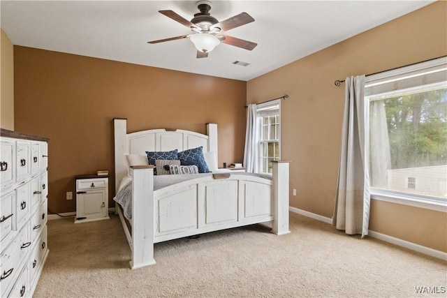 bedroom featuring light carpet, a ceiling fan, and baseboards
