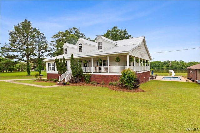 farmhouse featuring a porch, a front lawn, and an outdoor pool