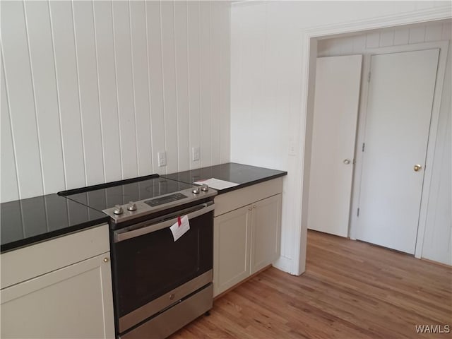kitchen with dark countertops, light wood finished floors, and stainless steel electric stove