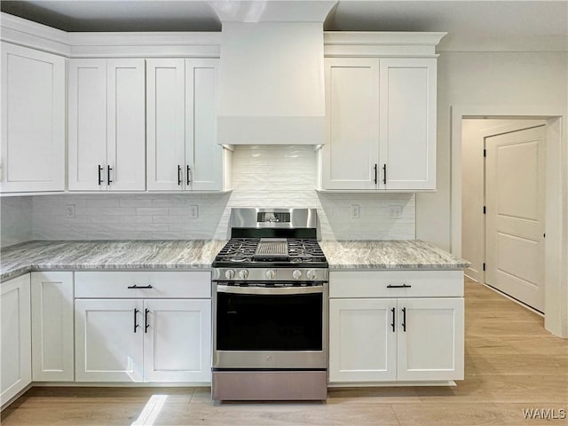 8 Northside Rd, Berry, AL 35546 - kitchen with gas stove, custom range hood, white cabinetry, and light wood finished floors