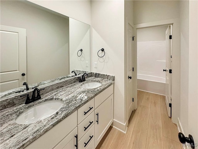 8 Northside Rd, Berry, AL 35546 - bathroom featuring wood finished floors, double vanity, baseboards, and a tub to relax in