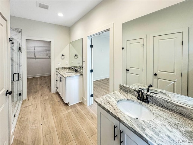 8 Northside Rd, Berry, AL 35546 - bathroom with a stall shower, two vanities, wood finished floors, baseboards, and recessed lighting