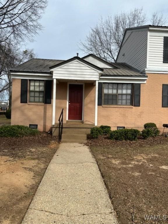 view of front of home with brick siding and metal roof