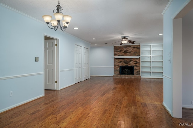 unfurnished living room featuring ceiling fan with notable chandelier, wood-type flooring, a fireplace, and ornamental molding