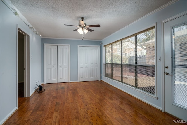 unfurnished bedroom featuring dark hardwood / wood-style floors, ceiling fan, and ornamental molding