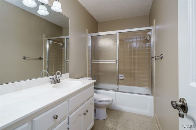 full bathroom featuring vanity, shower / bath combination with glass door, tile patterned flooring, toilet, and a textured ceiling