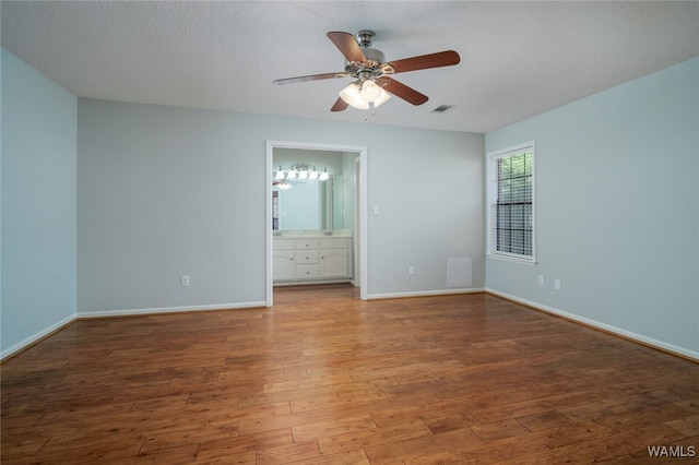 empty room featuring wood-type flooring and a textured ceiling