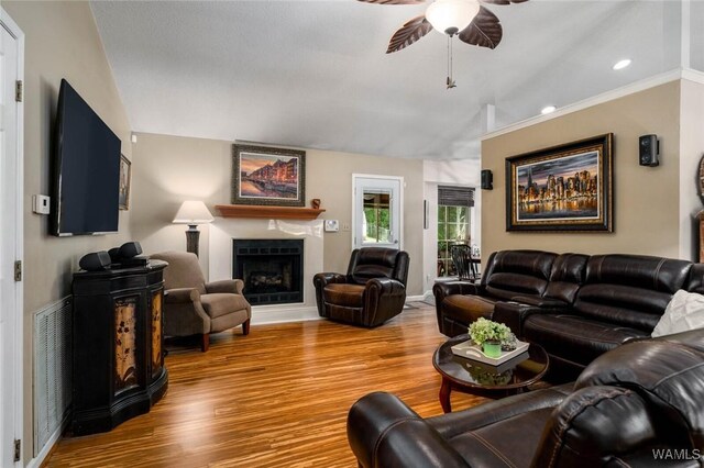 1428 Plymouth Ln, Tuscaloosa, AL 35406 - living room featuring ceiling fan, wood finished floors, a fireplace with raised hearth, crown molding, and vaulted ceiling