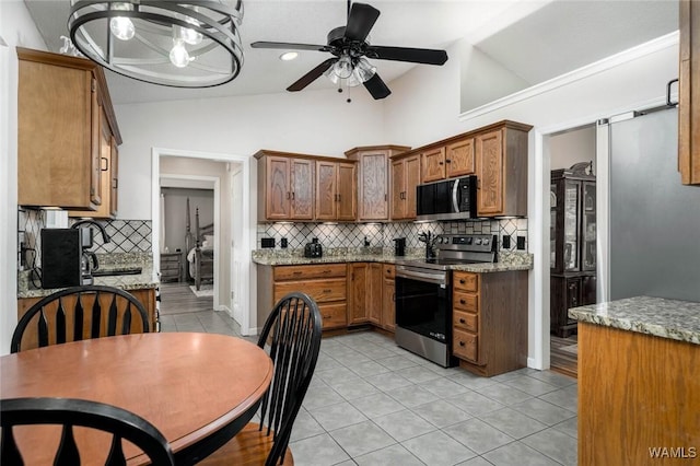1428 Plymouth Ln, Tuscaloosa, AL 35406 - kitchen with stainless steel appliances, vaulted ceiling, ceiling fan, decorative backsplash, and light tile patterned floors