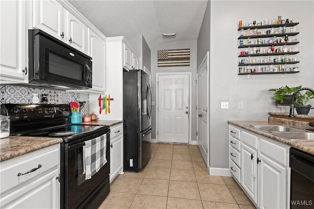 kitchen featuring sink, white cabinets, a textured ceiling, light tile patterned flooring, and black appliances