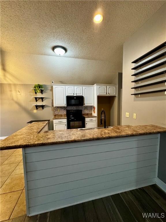 kitchen featuring sink, ceiling fan, light tile patterned floors, black dishwasher, and white cabinetry